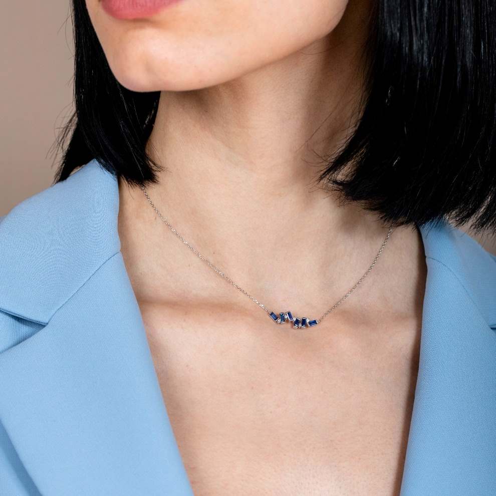 Woman wearing Blue Sapphire Baguette Necklace in 14K gold with geometric design and diamonds.
