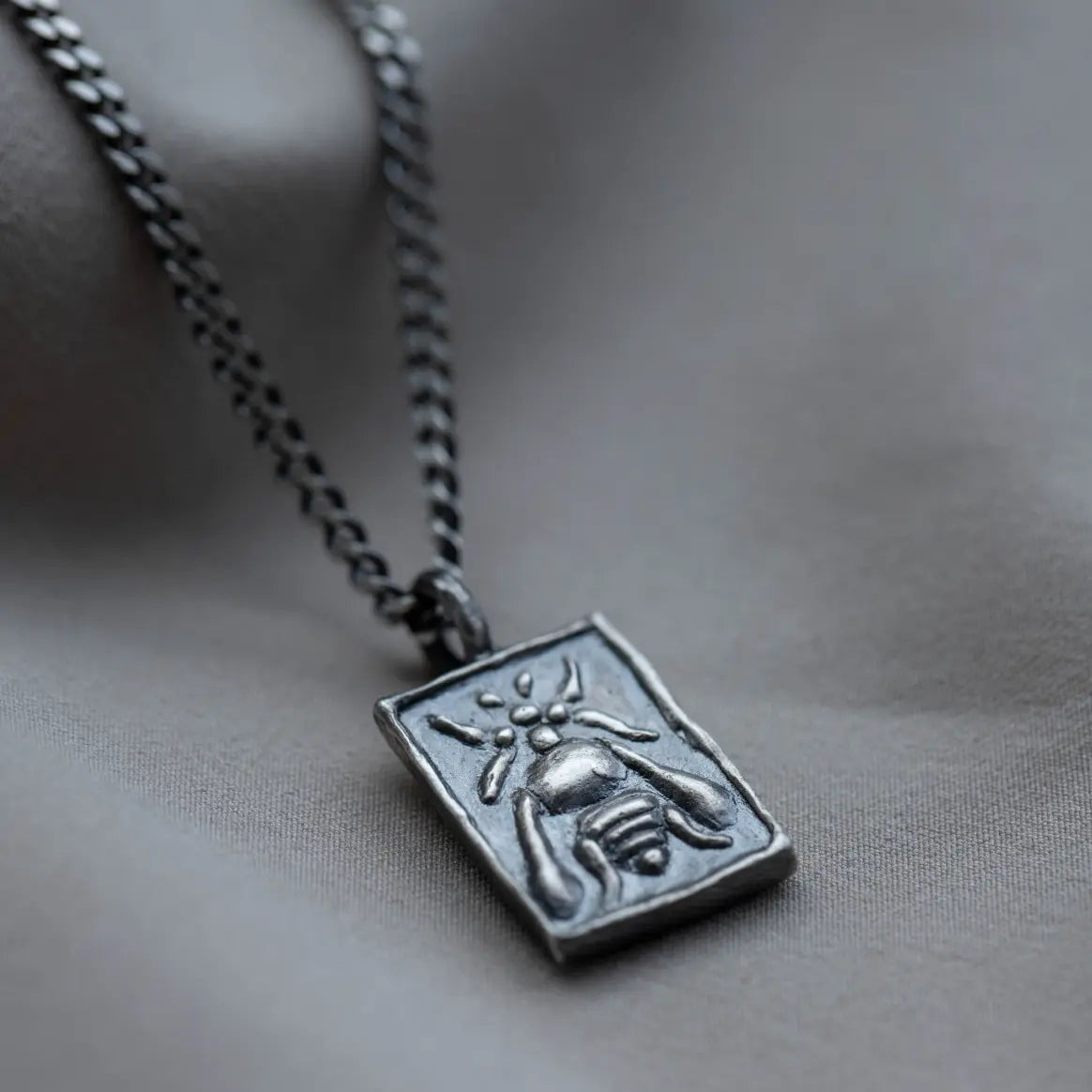 Ancient Greek Bee Necklace Oxidized Silver 925 on fabric background offering vintage charm and elegance.