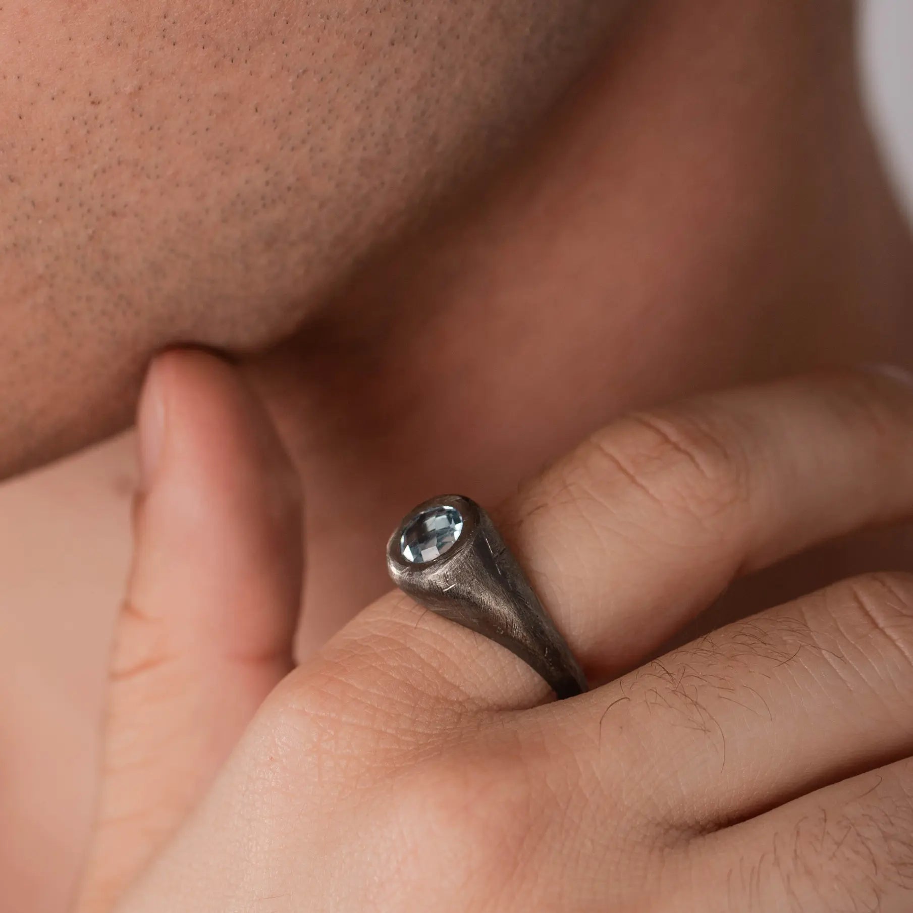 Man wearing Blue Topaz Ring on oxidized sterling silver, Brutalist style 925, black finish with 8mm gemstone, perfect men's gift.