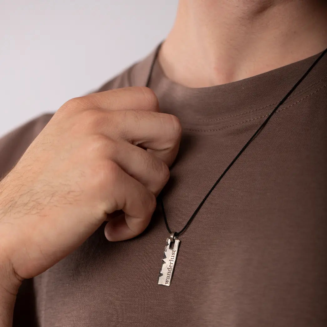 Man wearing personalized oxidized sterling silver necklace with vertical bar pendant.