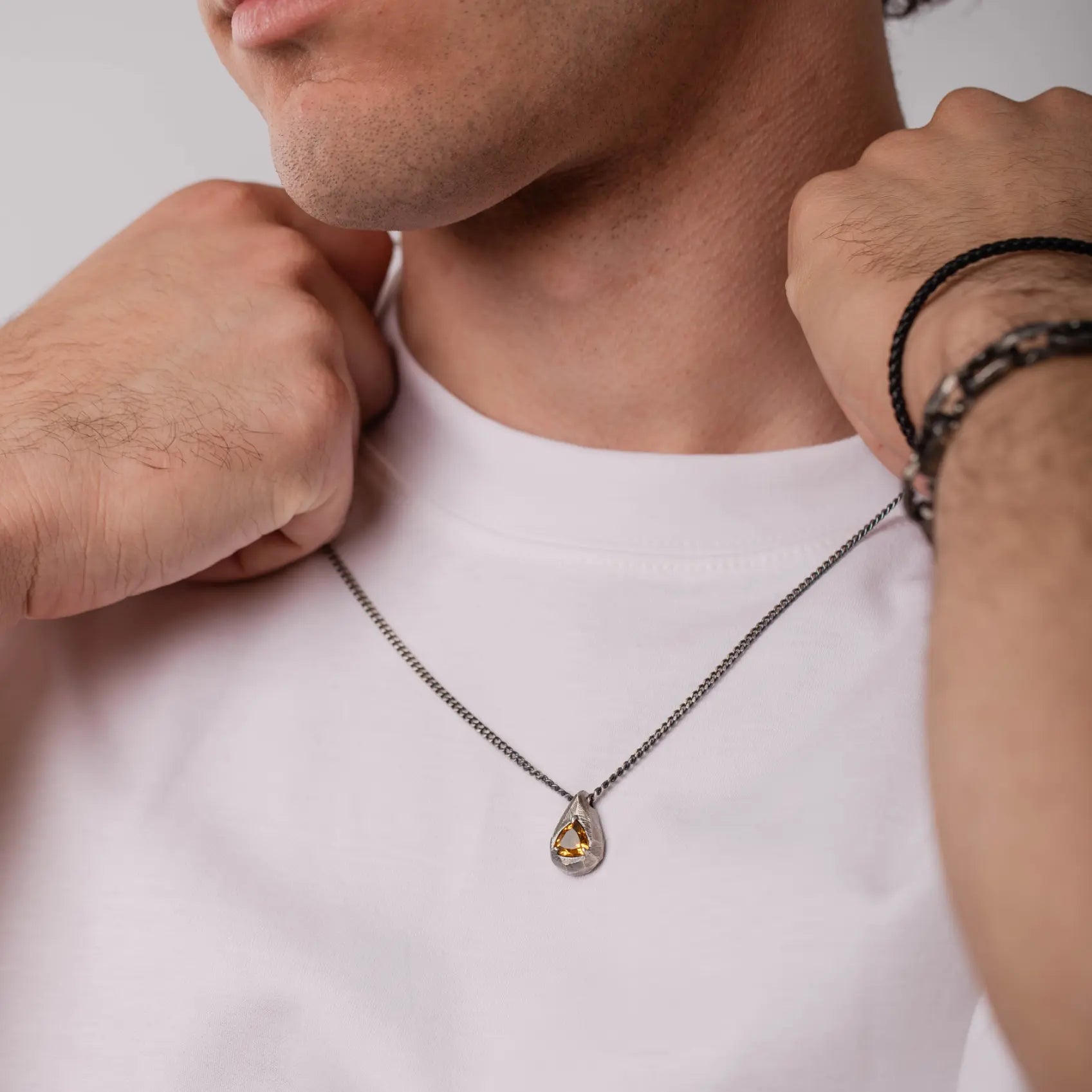 Man wearing citrine drop necklace oxidized silver with hand-carved sterling silver pendant.
