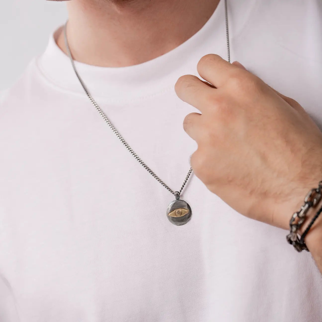 Evil Eye Necklace Brown Diamond Oxidized Silver 14K Gold on person wearing white shirt.