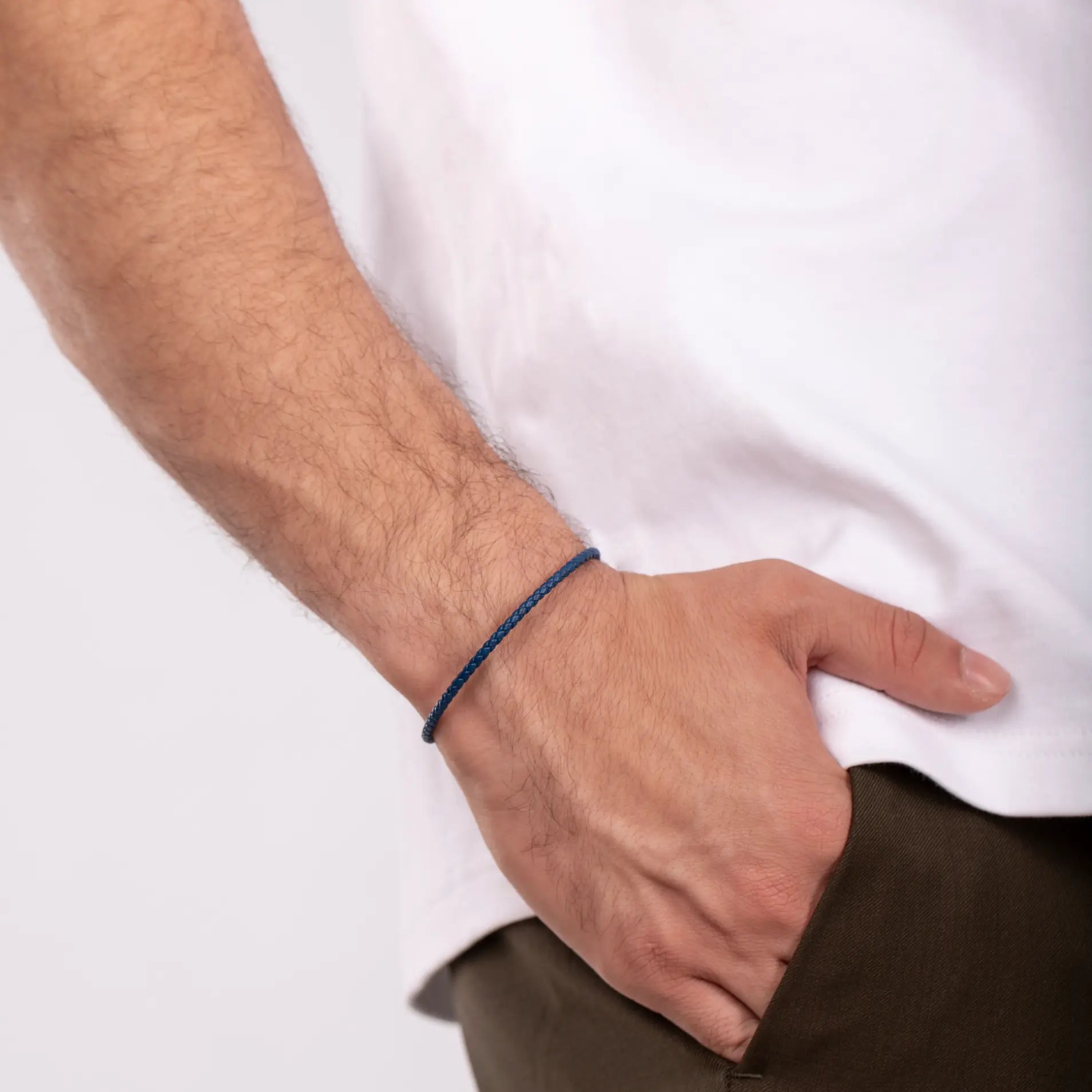 Close-up of a person wearing a Blue Leather Cord Bracelet with Oxidized Silver hook clasp.