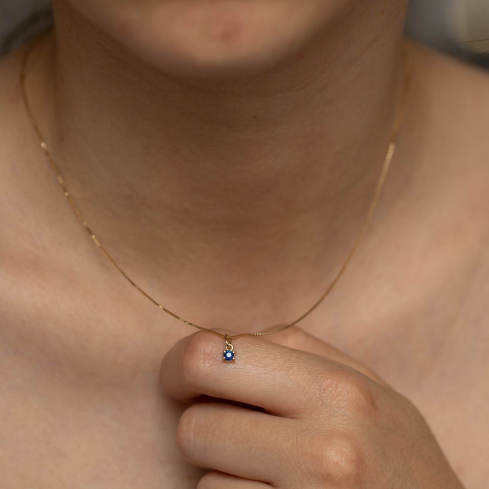 Solitaire Blue Sapphire Necklace in 14K Gold shown worn around the neck, featuring a round cut sapphire pendant.