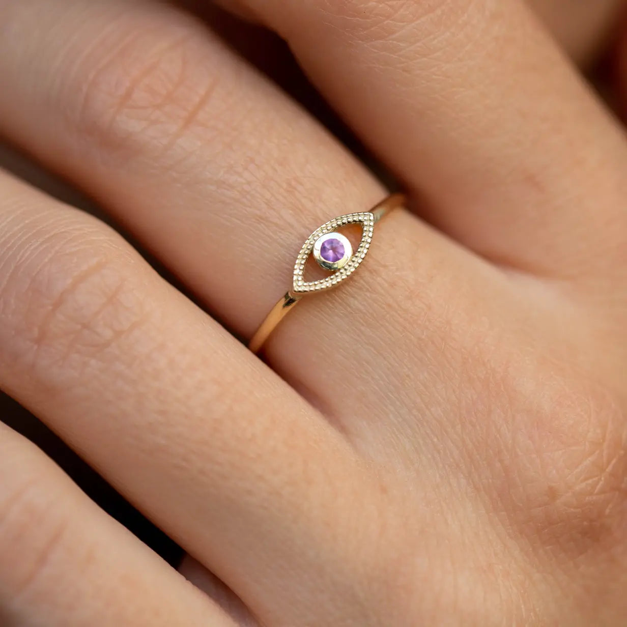 Amethyst Evil Eye Ring 14K Gold with purple amethyst stone, handmade, on woman's finger