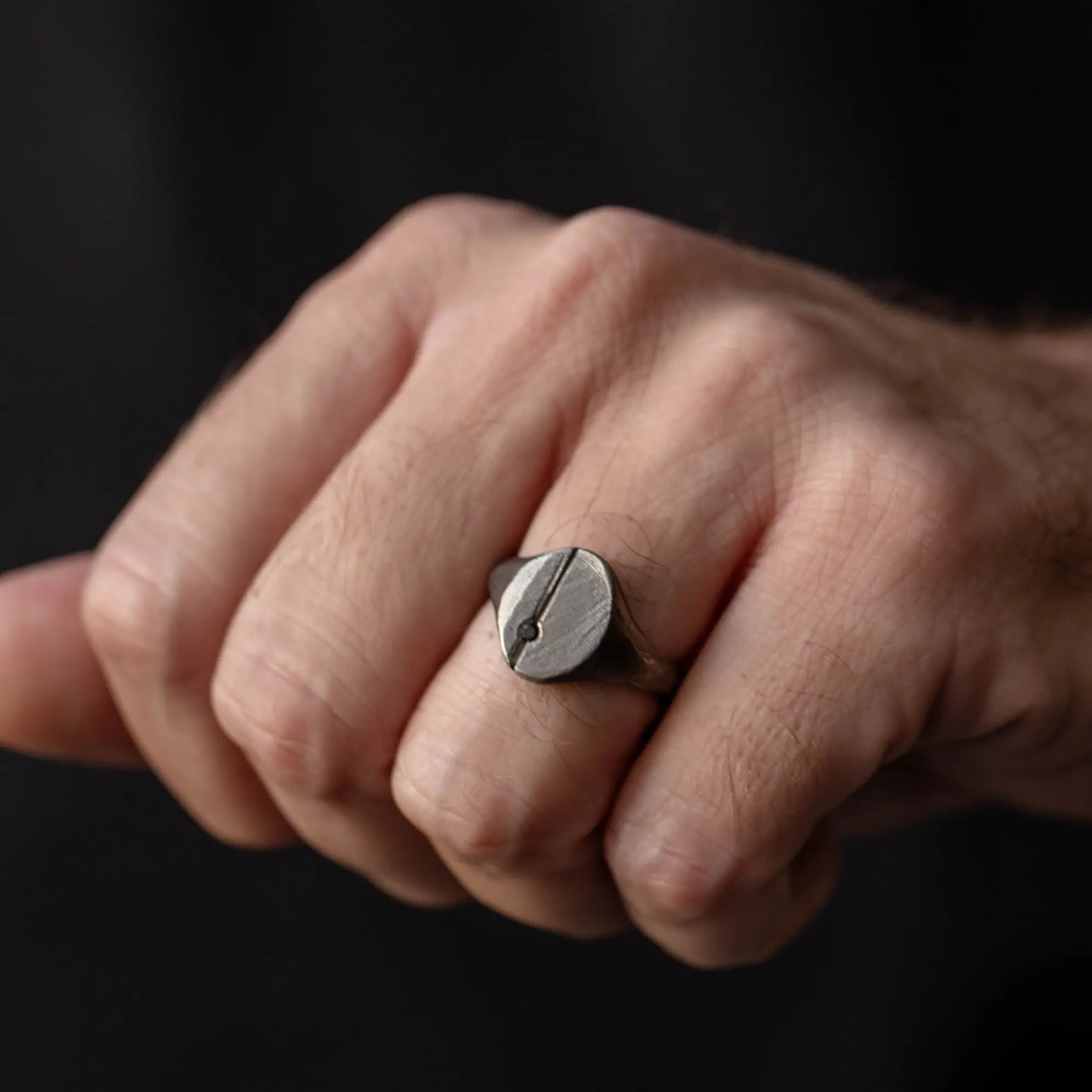 Black Diamond Oval Ring Oxidized Silver 925 on a man's hand, featuring a brutalist design with high-quality oxidized sterling silver and natural ruby.