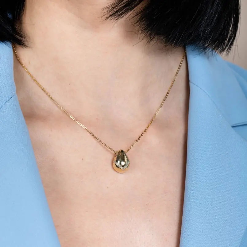 Woman wearing Statement Teardrop Diamond Necklace 14K Gold showcasing elegant 14K gold teardrop pendant with diamonds.