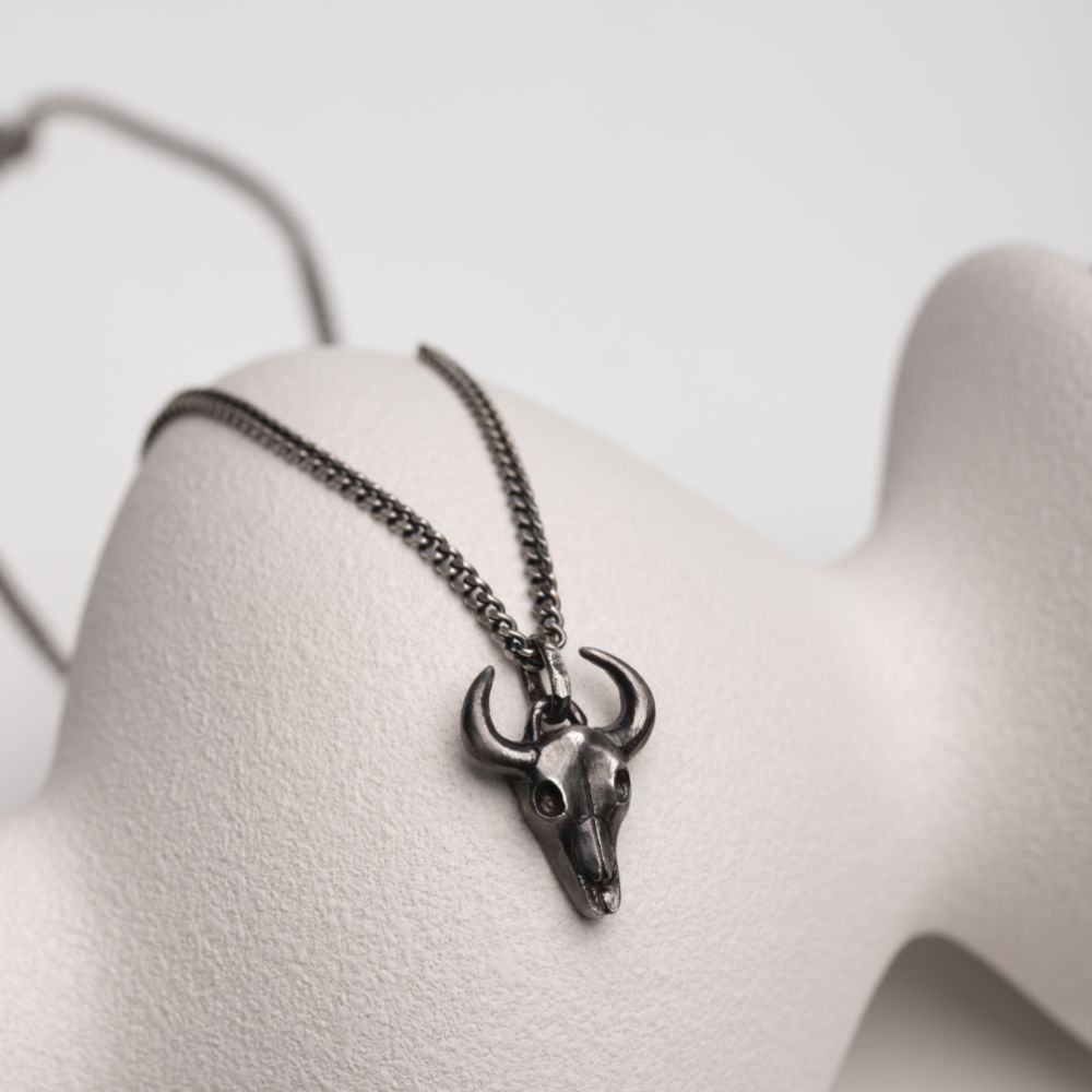 Oxidized sterling silver bull necklace with black oxidized finish and bull pendant on display.