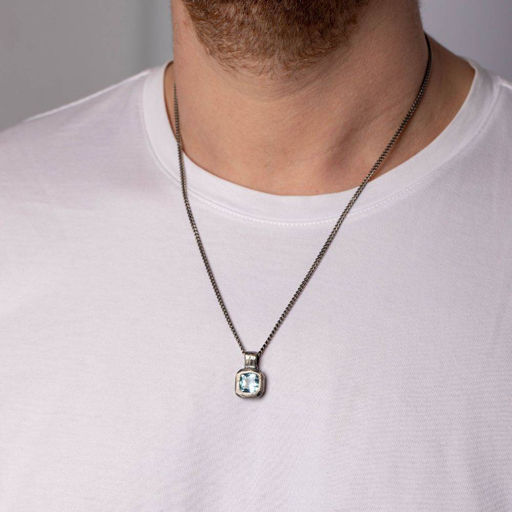 Blue Topaz Necklace Oxidized Silver 925 on model wearing white shirt, showcasing hand-carved pendant and gemstone, unisex design.