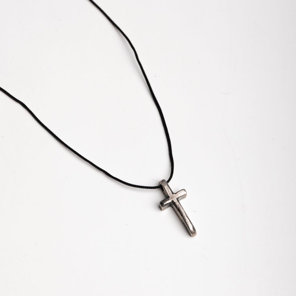 Men's sterling silver cross necklace with black oxidized finish on a thin black cord, perfect for a bold and timeless men's accessory.
