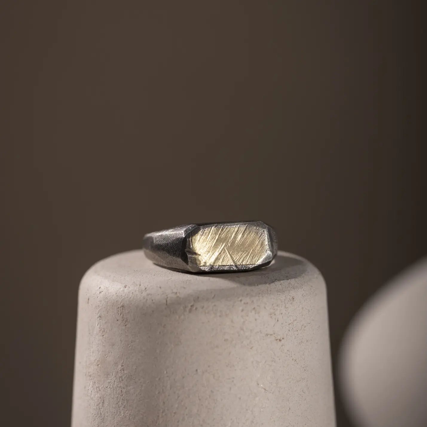 14K Gold Oxidized Silver 925 Signet Ring in brutalist style, handcrafted with black oxidized finish, displayed on a minimalist stand.