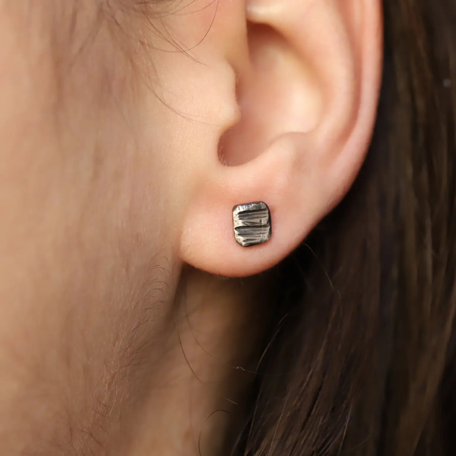 Oxidized Silver Square Stud Earrings on an ear, handmade sterling silver 925, 5mm x 6mm, unisex design, eco-friendly packaging.