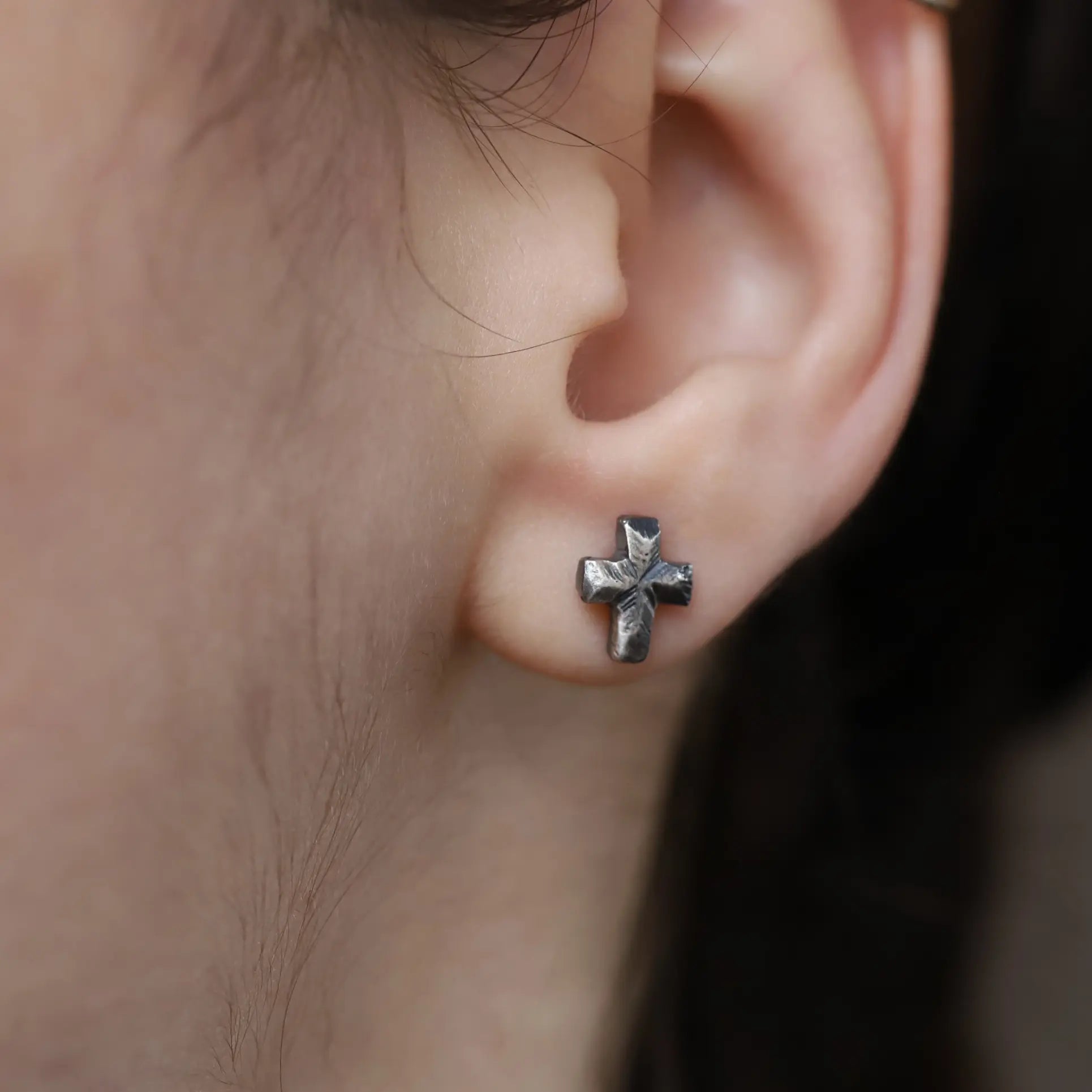 Oxidized Silver Cross Stud Earrings on ear, handmade sterling silver 925, 10mm x 7mm, unisex style.