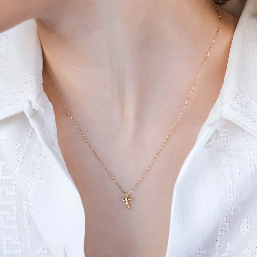 Alt Tag: Woman wearing Curvy Cross Necklace 14K Gold with elegant design, perfect for everyday wear, delivered with authenticity certificate.