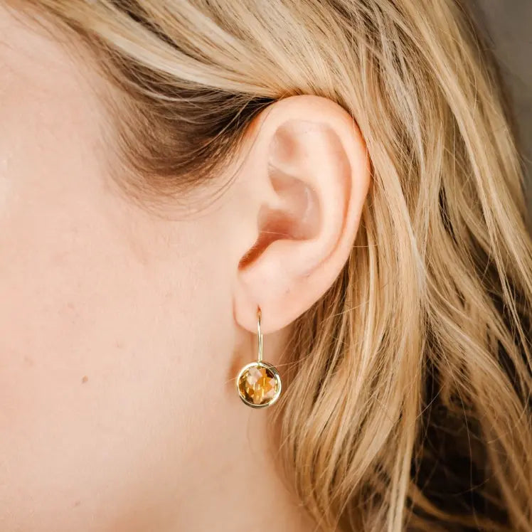 Citrine Earrings 10mm in 14K Gold worn elegantly on ear, handcrafted with gemstones, showcasing simplicity and elegance.