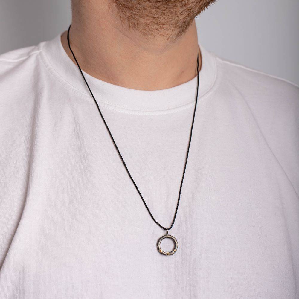Man wearing brown diamond circle necklace in sterling silver and 14K gold, featuring a black oxidized finish and 20mm circle pendant.