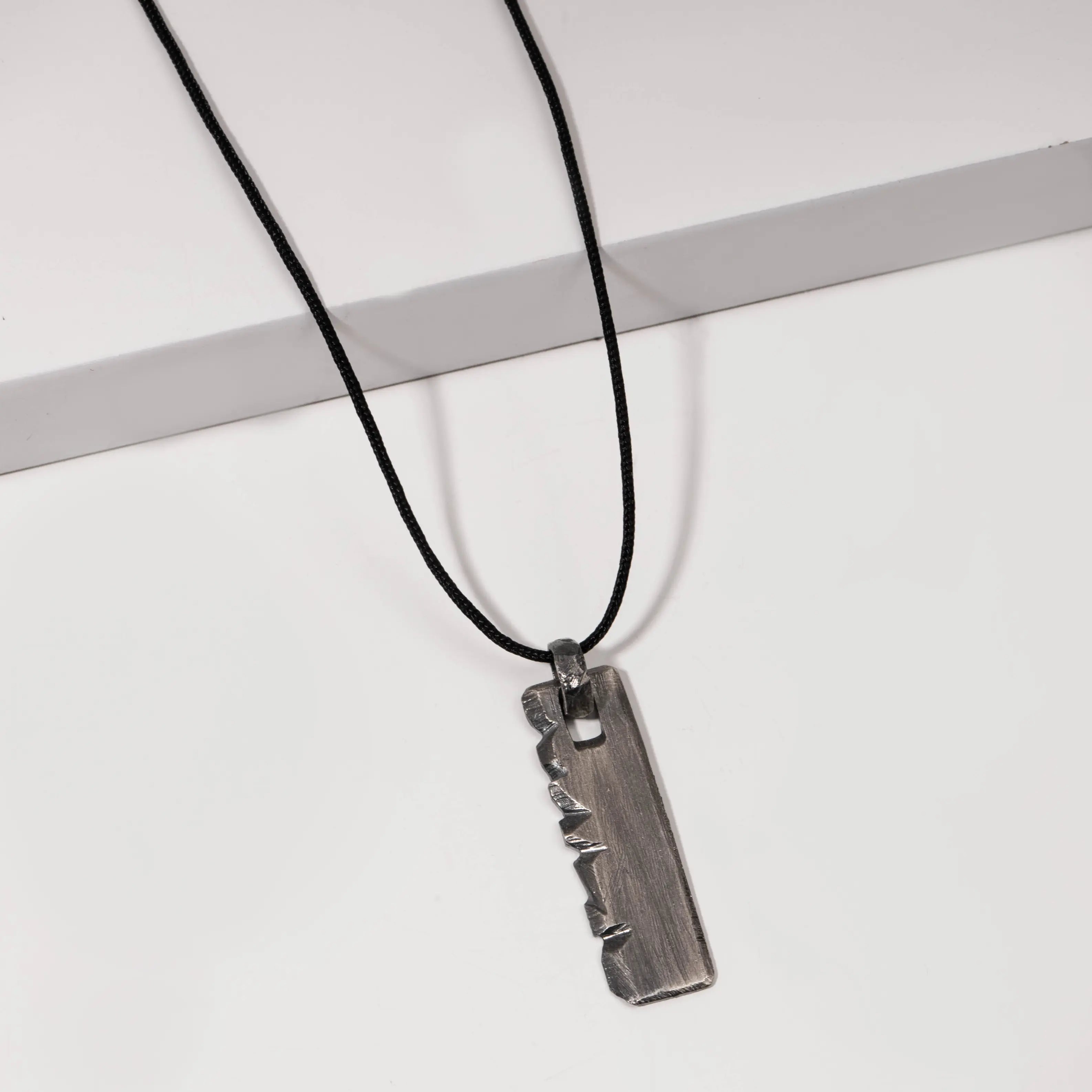 Personalized oxidized sterling silver necklace with vertical bar pendant on black cord.