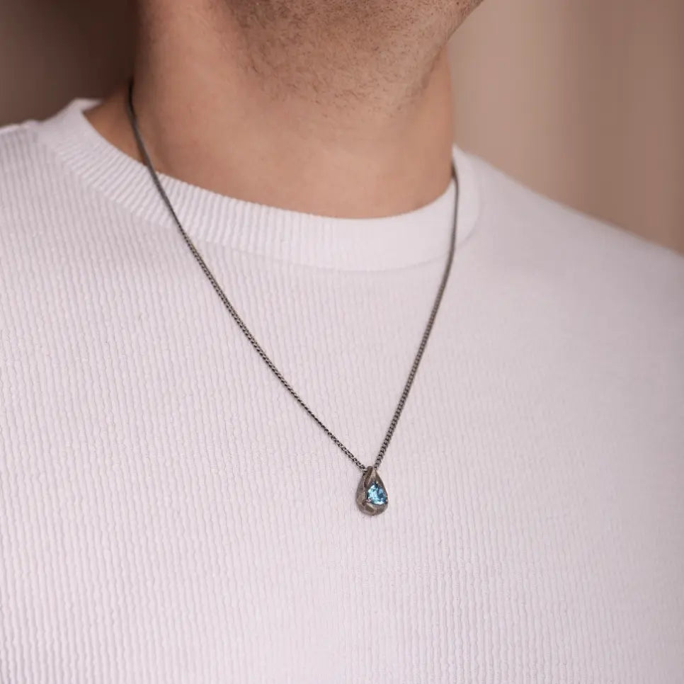 Model wearing Blue Topaz Drop Necklace Oxidized Silver with sterling silver chain and hand-carved pendant.
