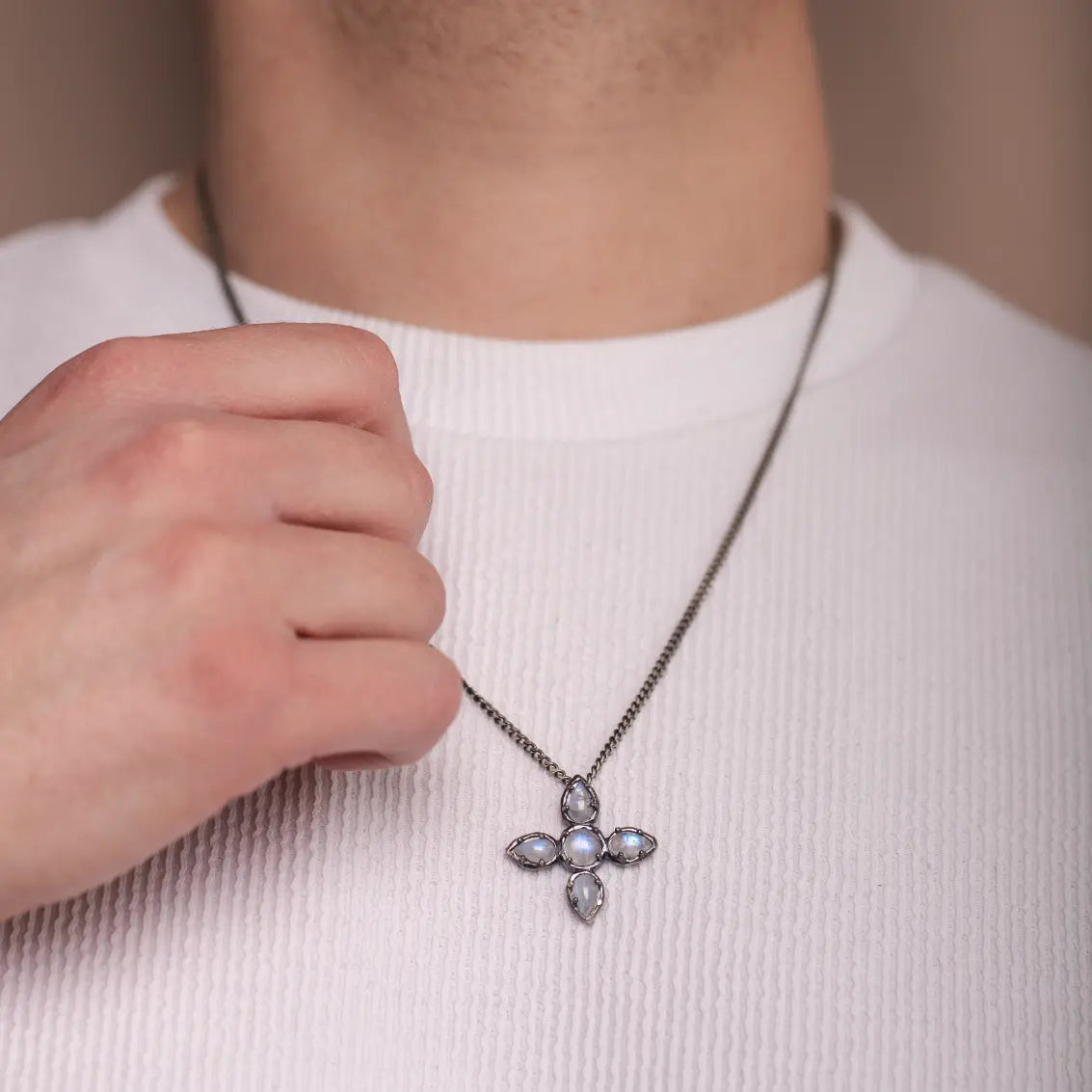 Person wearing large cross necklace moonstone oxidized silver