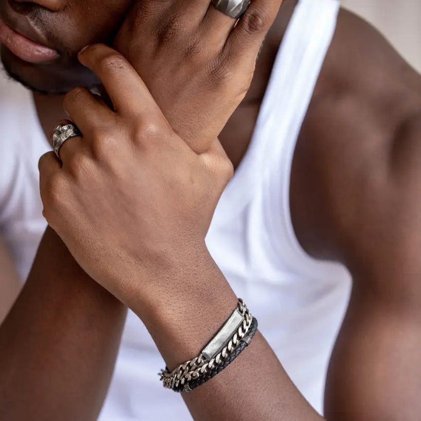 Man wearing personalized sterling silver ID bracelet with dark oxidized finish and curb chain.