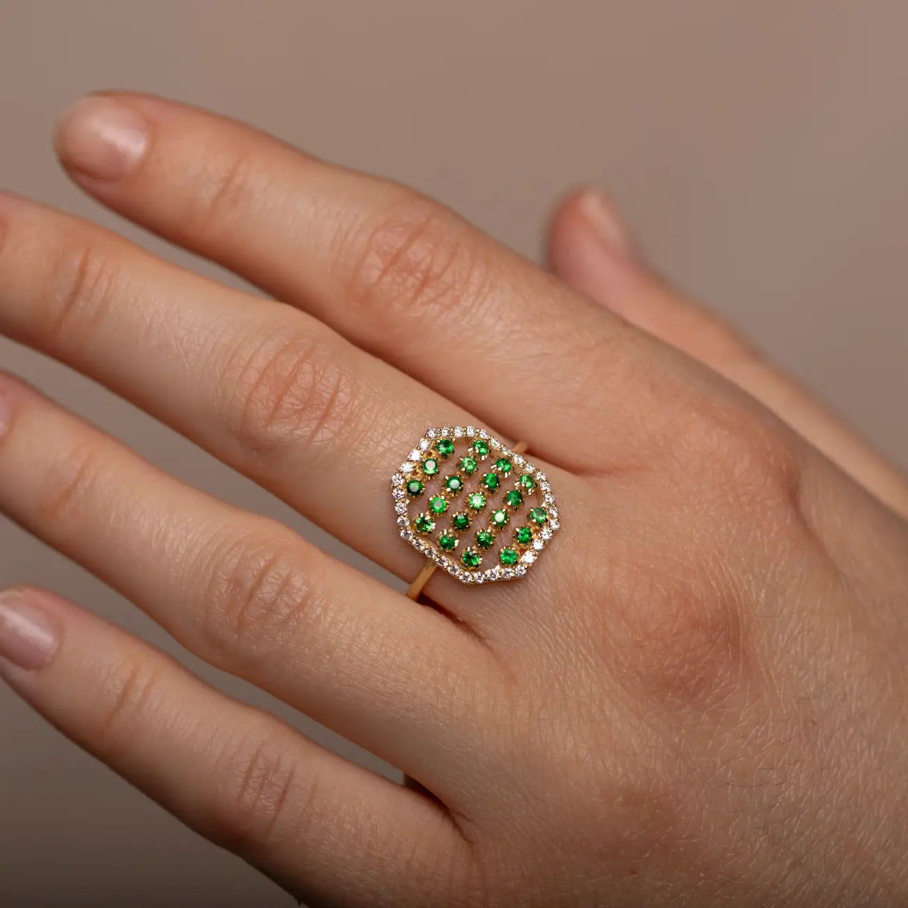 18K Gold Ring Octagon Tsavorites Diamonds on hand showcasing art deco design with green tsavorites and diamonds.