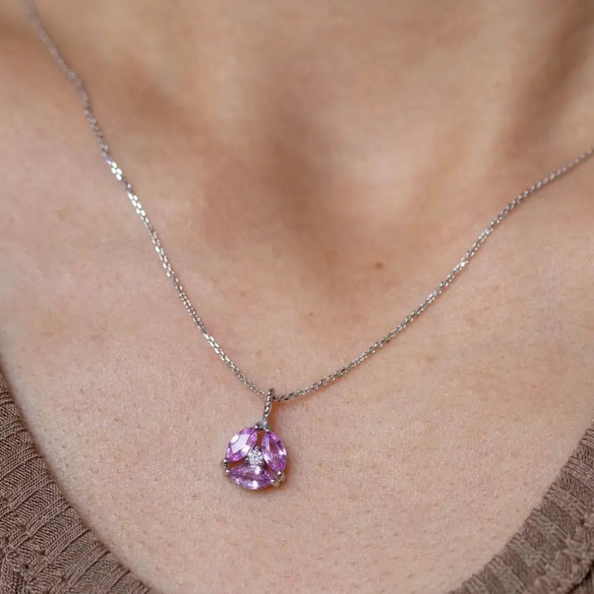 Close-up of a Pink Sapphire Diamond Necklace 14K Gold Flower worn on a woman's neck, featuring marquise-cut pink sapphires and diamond.