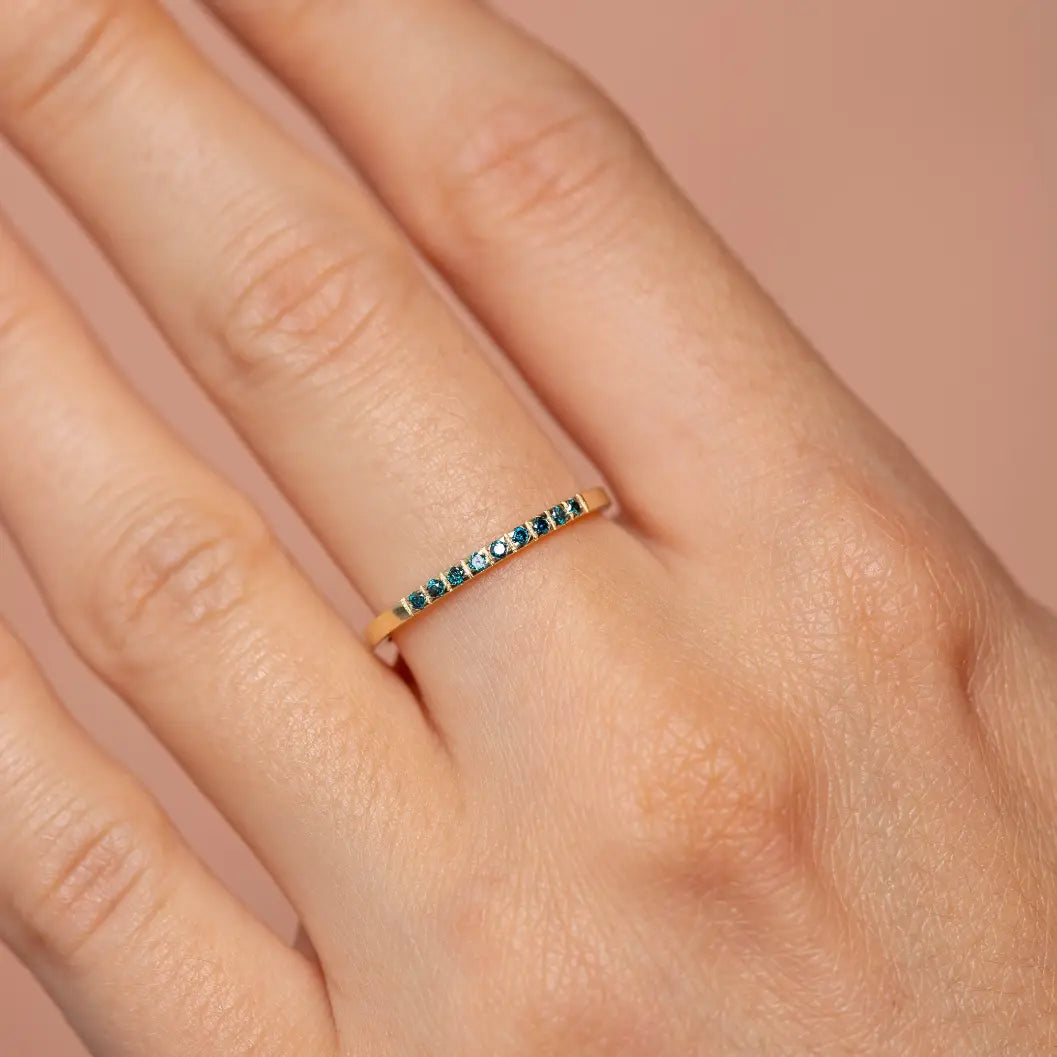 9 Blue Diamond Wedding Band 14K Gold on hand, showcasing brilliant cut pave setting in solid gold, elegant stacking ring for women.