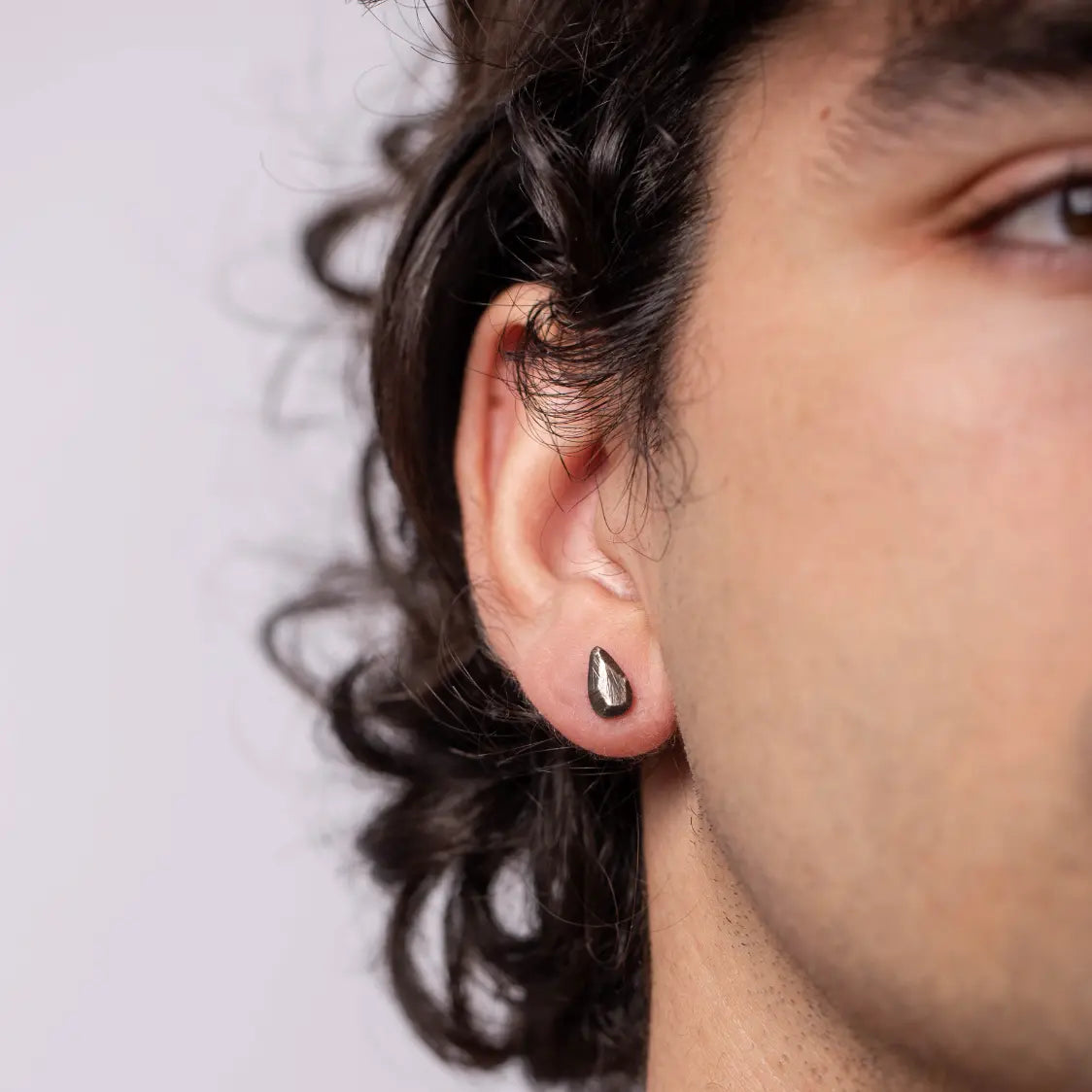 Oxidized Silver Teardrop Stud Earrings on person's ear, handmade from sterling silver 925, 10mm x 6mm, in eco leather pouch.