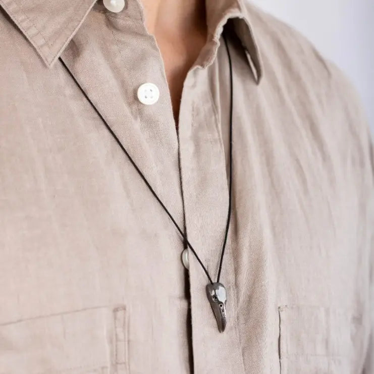 Raven Skull Necklace Oxidized Silver worn by man with beige shirt, gothic men's jewelry, handmade sterling silver, Viking crow design.