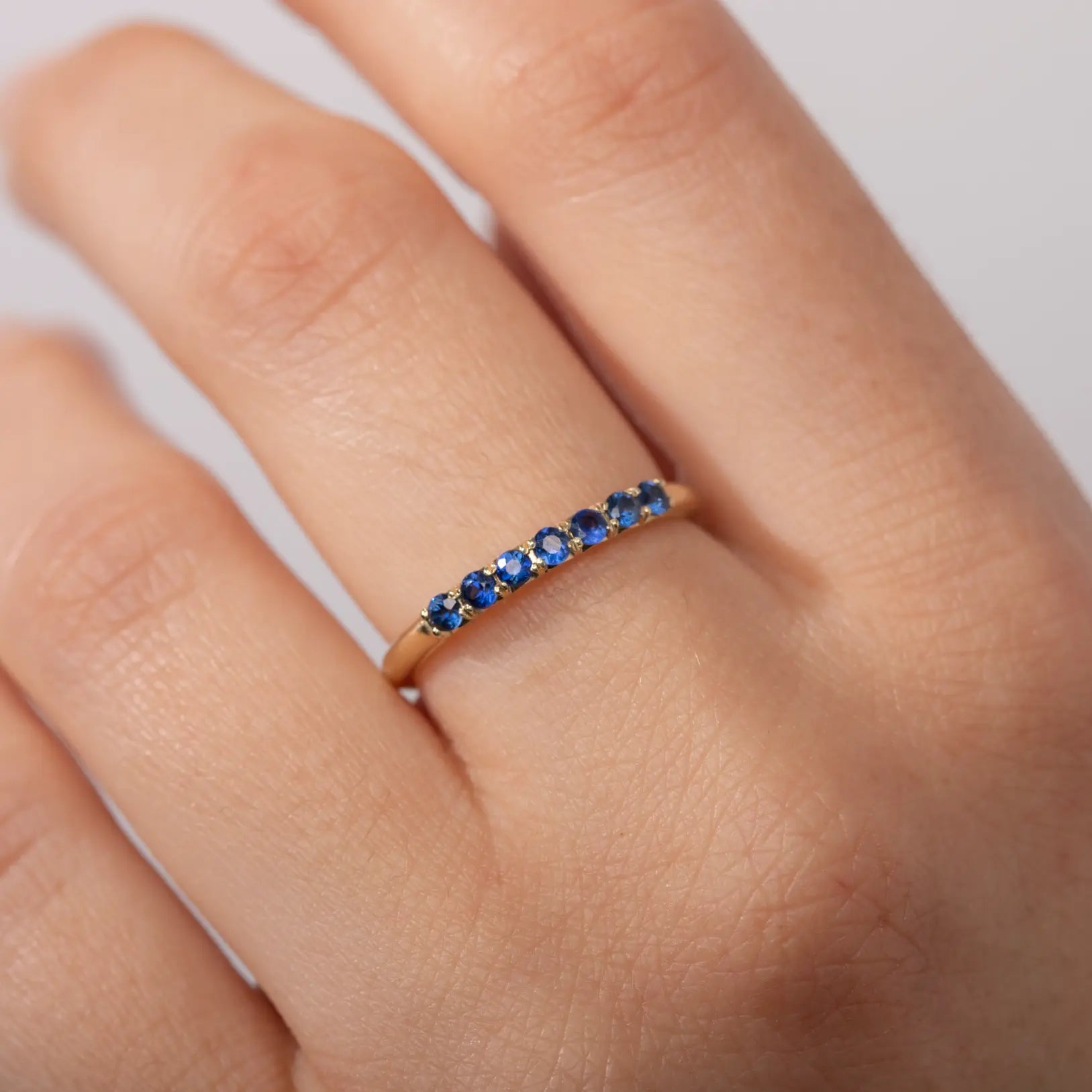 Half Eternity Ring Blue Sapphires 14K Gold with natural sapphires on a hand, perfect anniversary gift.