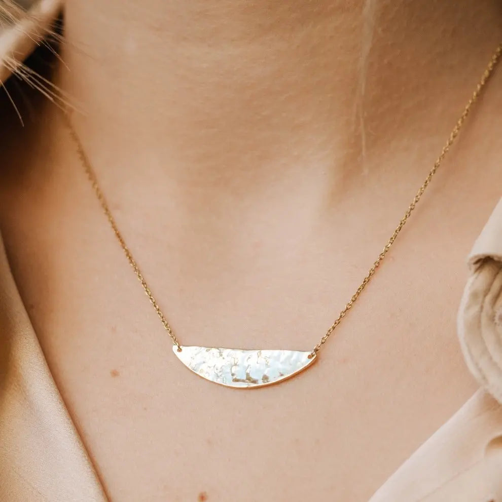 Silver textured necklace with semicircle design on model's neck