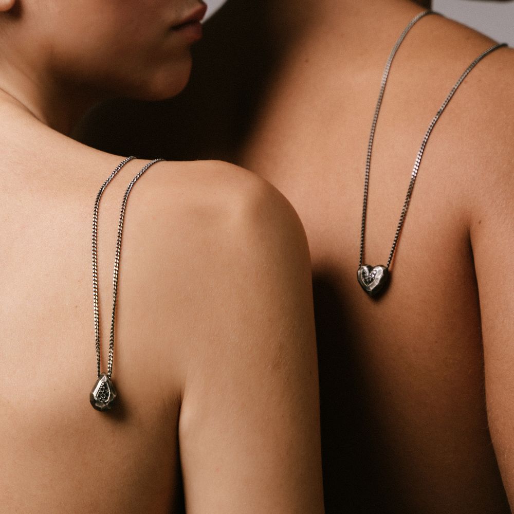 Two models wearing the Drop Necklace Oxidized Silver Black Diamonds with teardrop pendants on their backs.