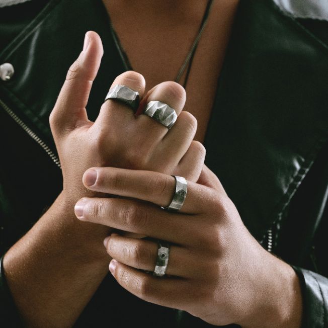 Man wearing black diamonds band ring oxidized silver in brutalist style.