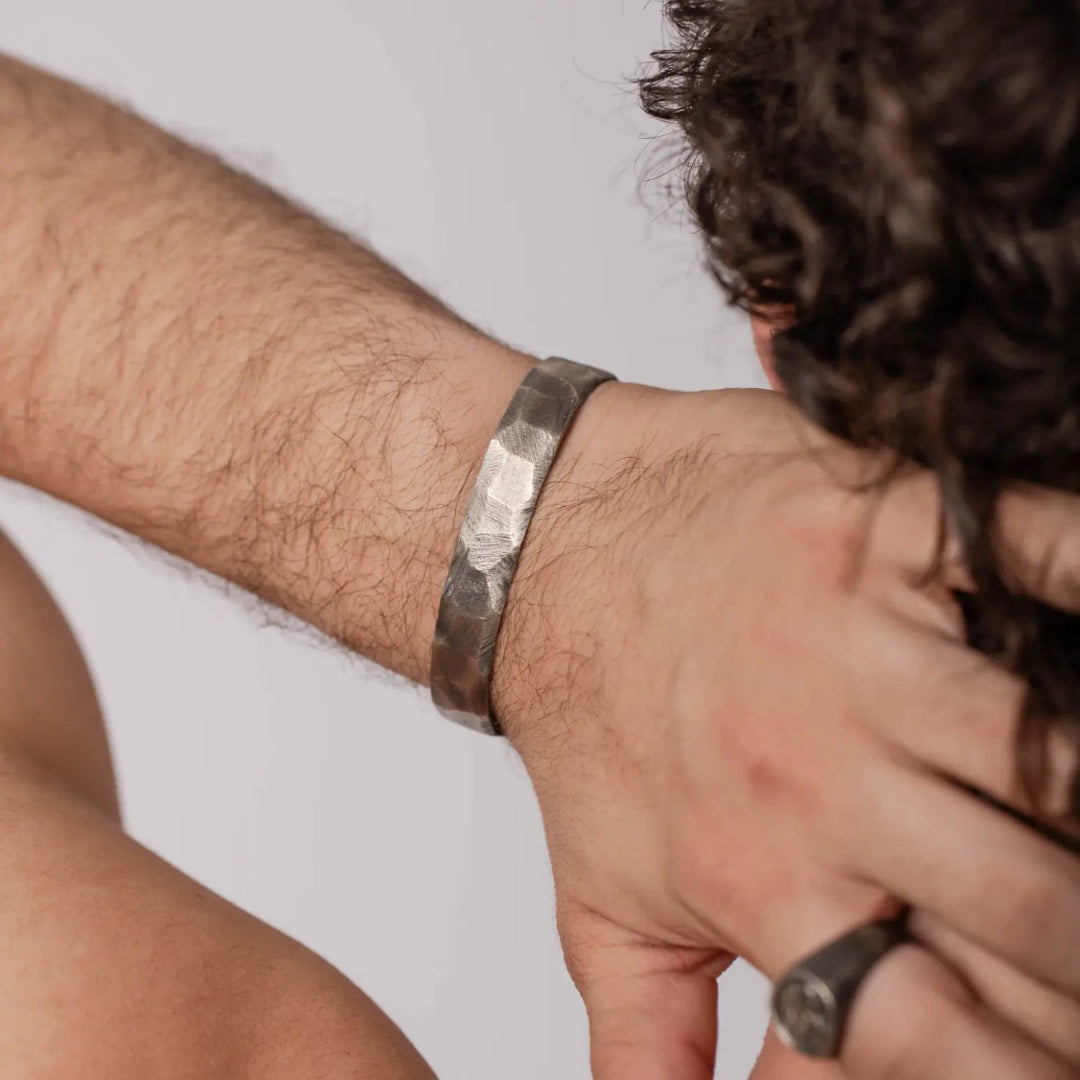 Person wearing oxidized silver cuff bracelet for men and women, made from high quality sterling silver, 11mm width, black oxidized finish.