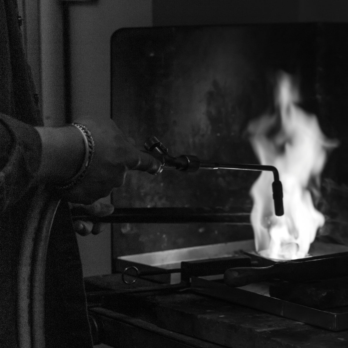 Person using a torch to work on metal in a workshop setting