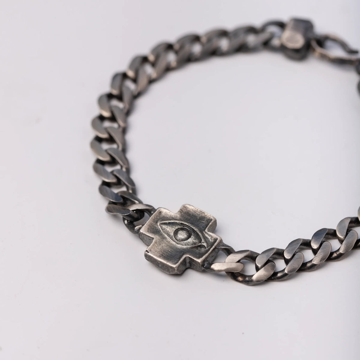 Close-up of Men's Cross and Evil Eye Bracelet in Oxidized Silver
