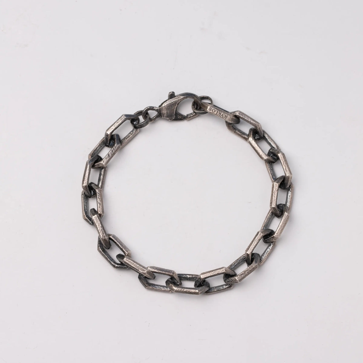 Angular-link bracelet in oxidized silver on a neutral background