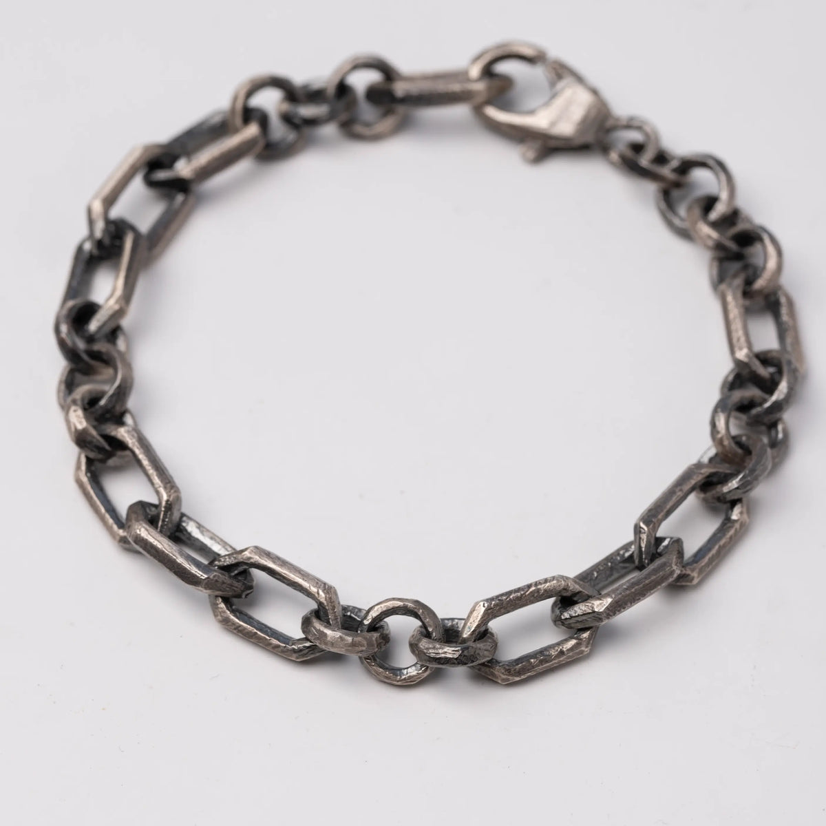 Mixed geometric-link bracelet in oxidized silver on a neutral background