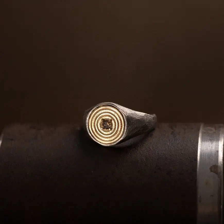 Round Ring 14K Gold and Silver With Brown Diamond on dark surface showcasing brutalist design.