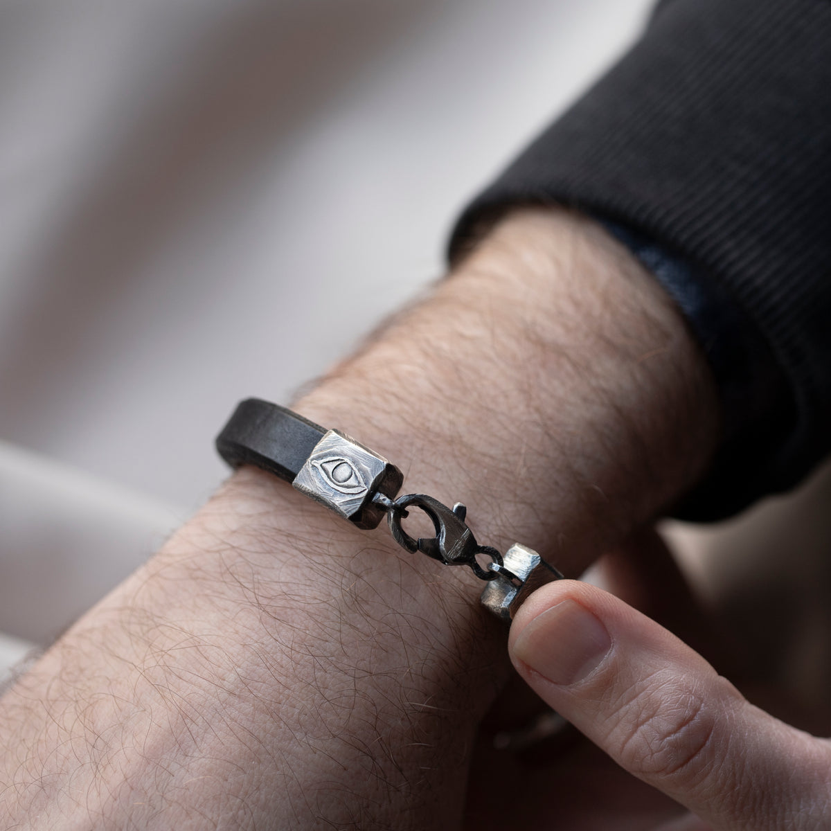 Men's Leather Bracelet with Oxidized Silver Evil Eye Clasp worn on a man's wrist