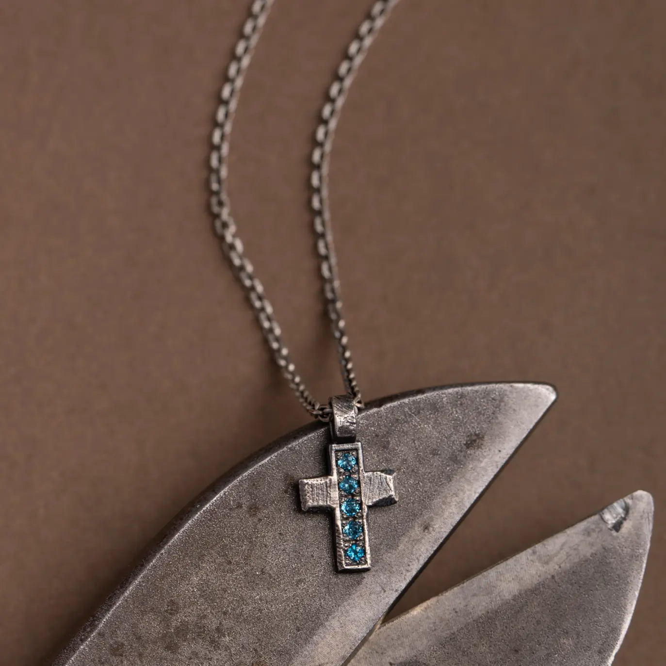 Oxidized Silver Cross Necklace featuring London Blue Topaz gemstones on a silver chain.