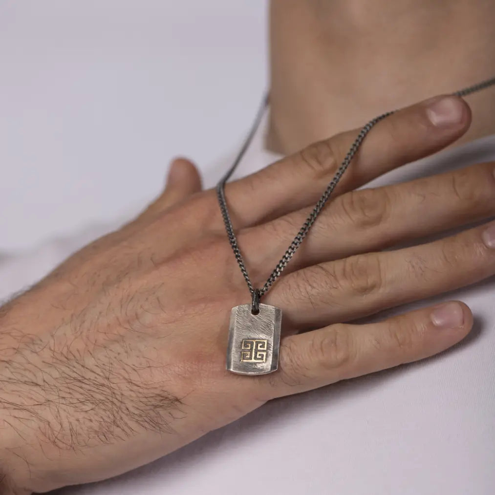 Greek Key Necklace Oxidized Silver 14K Gold with meander pattern displayed on a person wearing a white shirt.